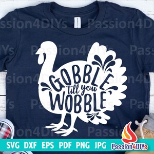 May include: A navy blue t-shirt with a white silhouette of a turkey with the text "Gobble till you wobble" inside the turkey.