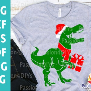 クリスマス恐竜 SVG、恐竜サンタ SVG、メリークリスマス SVG、ホリデー T-Rex カットファイル DXF、Eps PNG 面白い子供用シャツ SVG、シルエット Cricut