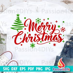 May include: White t-shirt with red and green text that says "Merry Christmas" with a green Christmas tree and snowflakes.