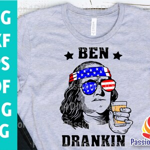 May include: A gray t-shirt with a black and white illustration of Ben Franklin wearing a red, white, and blue headband and sunglasses. The text "BEN DRINKIN'" is below the illustration.