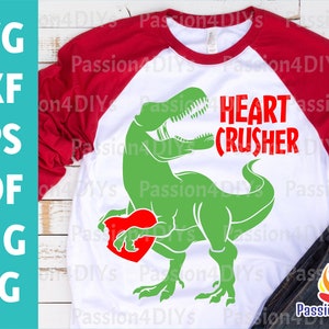 May include: A white t-shirt with a red and green graphic of a dinosaur holding a heart. The text "HEART CRUSHER" is written in red above the dinosaur.
