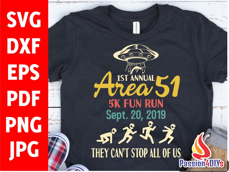 May include: Black t-shirt with a graphic design for the 1st Annual Area 51 5K Fun Run, Sept. 20, 2019. The design includes a UFO, aliens, and the text "THEY CAN'T STOP ALL OF US."