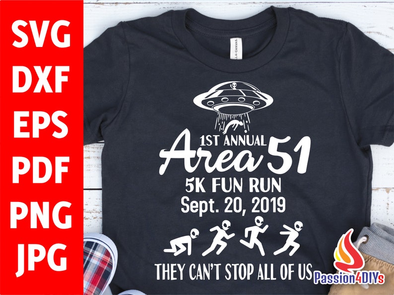 May include: Black t-shirt with white graphic text and illustrations. The design includes a UFO, the words "1st Annual Area 51 5K Fun Run Sept. 20, 2019," and alien figures running. The phrase "THEY CAN'T STOP ALL OF US" is also included.