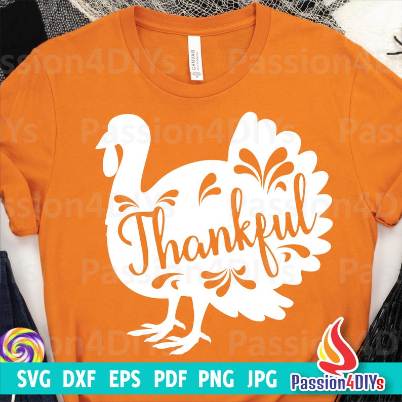 May include: Orange t-shirt featuring a white silhouette of a turkey with the word "Thankful" inside the turkey. The design is ideal for Thanksgiving.