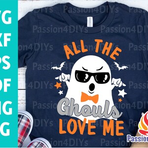 Könnte beinhalten: Ein dunkelblaues T-Shirt mit einem weißen Geist, der eine Sonnenbrille und eine Fliege trägt. Der Text "All the Ghouls Love Me" ist in Orange auf dem Shirt gedruckt.