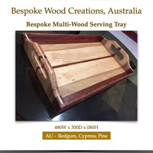 May include: A rectangular serving tray crafted from redgum, cypress, and pine wood, featuring integrated handles on the sides. The tray displays text reading Bespoke Wood Creations, Australia, Bespoke Multi-Wood Serving Tray, 480W x 300D x 080H.