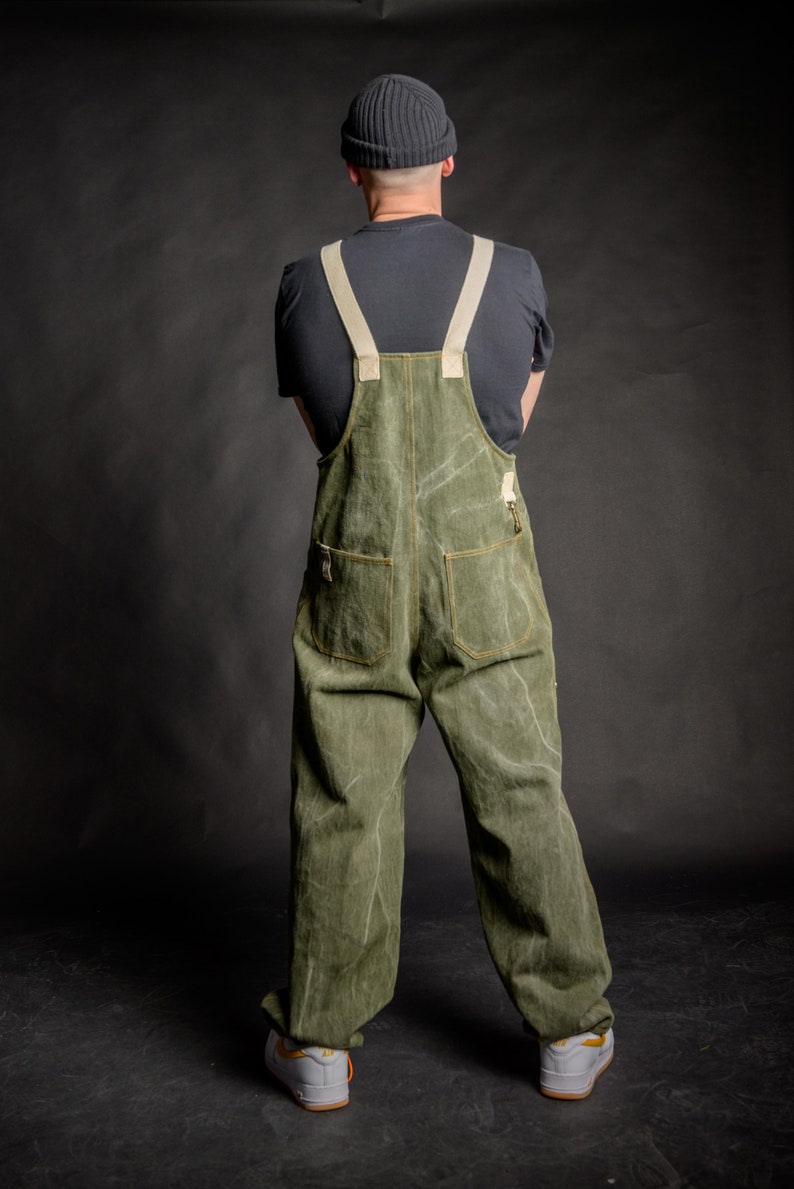 Man wearing a fashionable unisex streetwear salopette with two back pockets and adjustable elastic ankle cuffs.