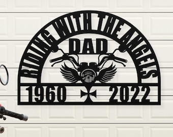 Puede incluir: Placa de metal negro con el texto "Riding with the Angels Dad 1960 - 2022". La placa presenta una motocicleta con alas y una cruz.
