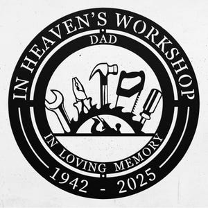 May include: Black metal workshop sign with the text "IN HEAVEN'S WORKSHOP" and "IN LOVING MEMORY". The sign features a circular design with tools like a wrench, pliers, hammer, saw, and screwdriver. The years 1942-2025 are also included.