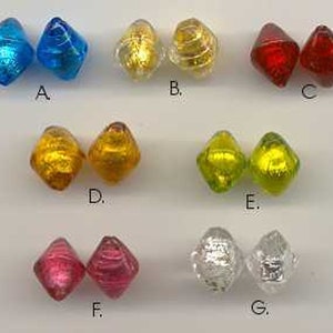 Pode incluir: Conjunto de 12 contas de vidro em várias cores, incluindo azul, dourado, vermelho, verde e prata. Cada conta tem a forma de um diamante com um padrão de espiral.