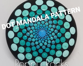 May include: A black round rock with a teal, blue, and white dot mandala pattern. The text "DOT MANDALA PATTERN" is written above the mandala and "Poppy Rocks" is written below the mandala.