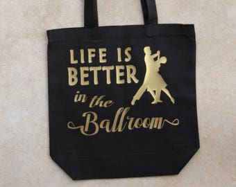 May include: Black canvas tote bag with gold text that reads "Life is better in the Ballroom" and a silhouette of a ballroom dance couple.