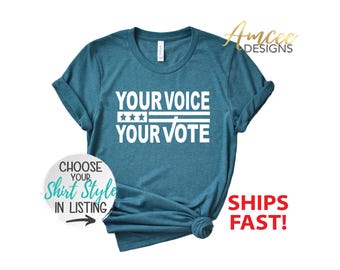 May include: A teal blue t-shirt with white text that reads "YOUR VOICE YOUR VOTE" with three white stars above the word "VOTE".