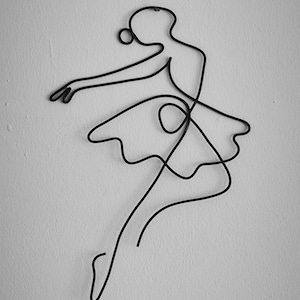 May include: A black metal wire sculpture of a ballerina in a flowing skirt, posed in mid-air with one leg extended.