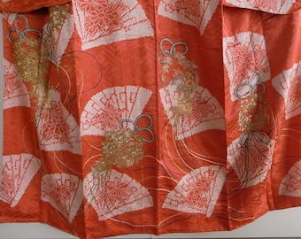 May include: A red silk kimono with a white and gold pattern of fans and flowers. The kimono is decorated with gold thread embroidery.