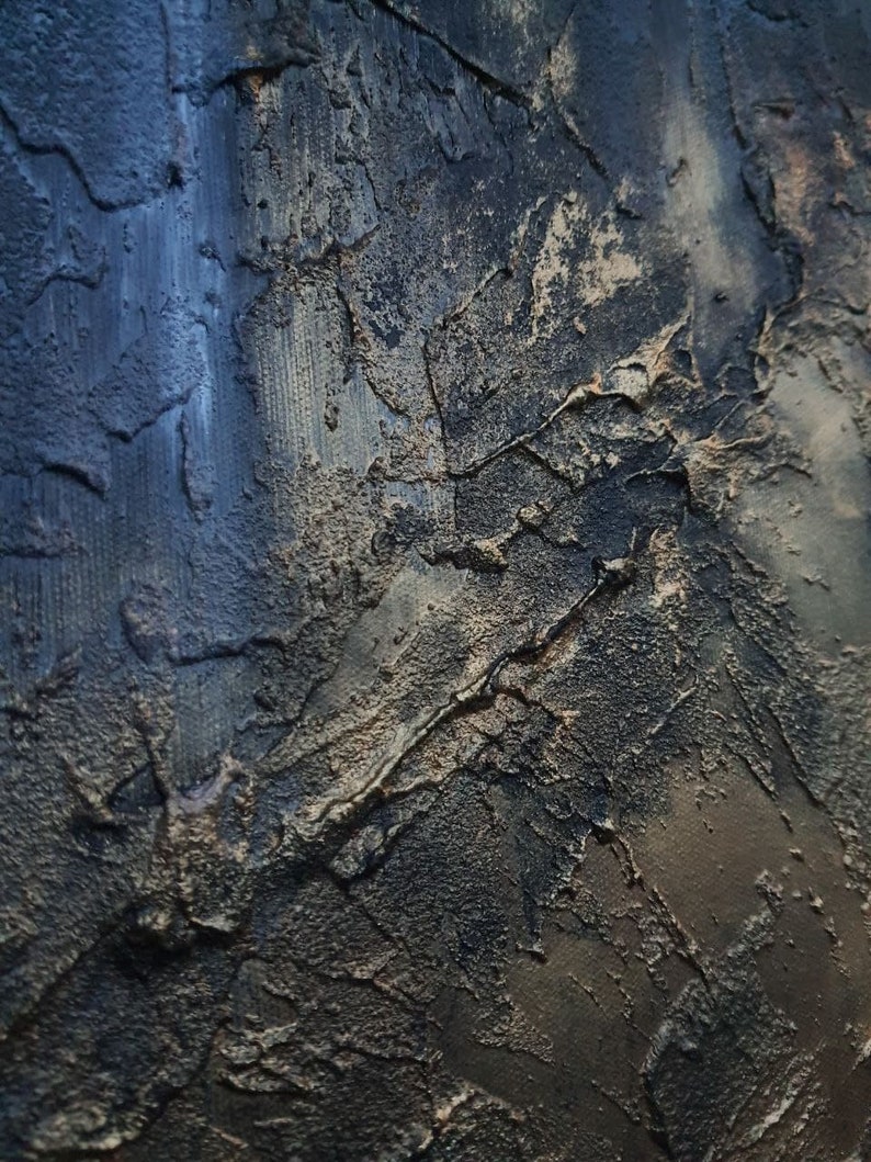 May include: A close-up of a textured, dark blue and gold surface. The surface has a rough, uneven texture, with deep cracks and crevices. The colors are muted and blend together seamlessly, creating a sense of depth and dimension.