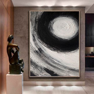 May include: Abstract painting with black and white swirling brushstrokes. The painting features a large white circle in the center, surrounded by black brushstrokes.