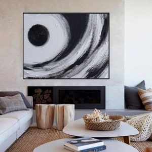 May include: Abstract painting with black and white brushstrokes, featuring a large black circle in the center. The painting has a modern and minimalist style.