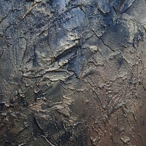 May include: A textured, abstract painting with a dark blue and gold color scheme. The paint has been applied in a thick, impasto style, creating a three-dimensional effect.