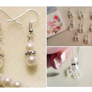 May include: A set of pearl and rhinestone earrings. The earrings are silver and have two white pearls on each earring. The pearls are separated by a rhinestone band.