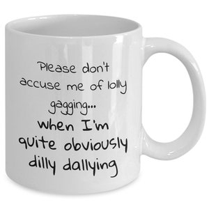 May include: White ceramic coffee mug with black text that reads "Please don't accuse me of lolly gagging... when I'm quite obviously dilly dallying"