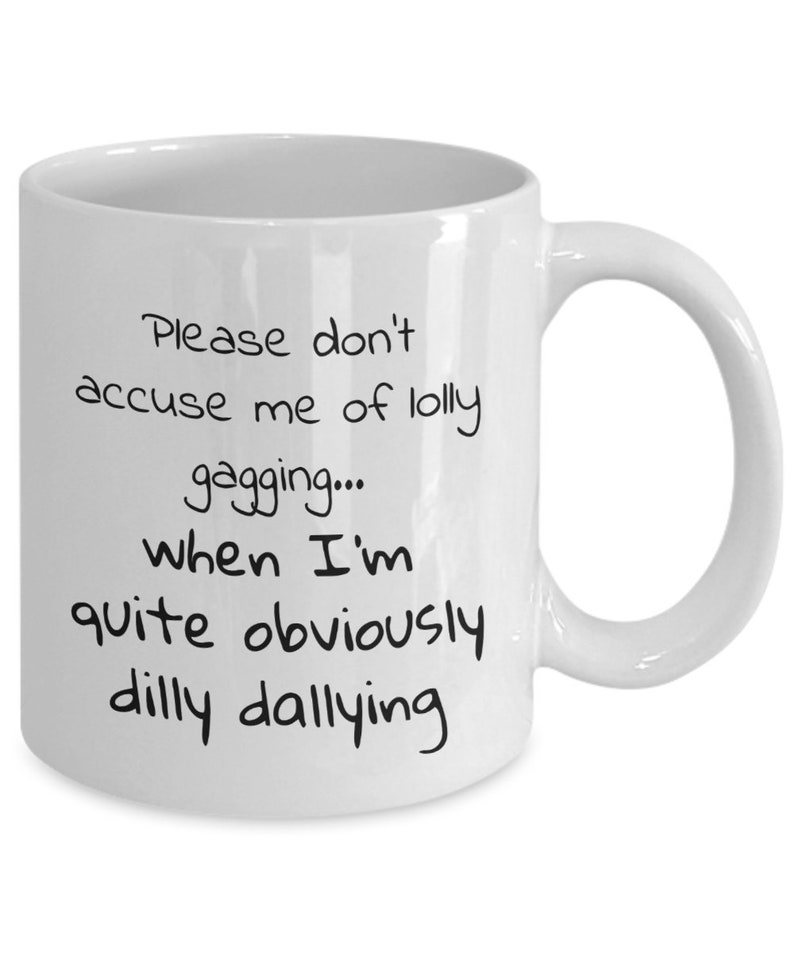May include: White ceramic coffee mug with black text that reads "Please don't accuse me of lolly gagging... when I'm quite obviously dilly dallying"