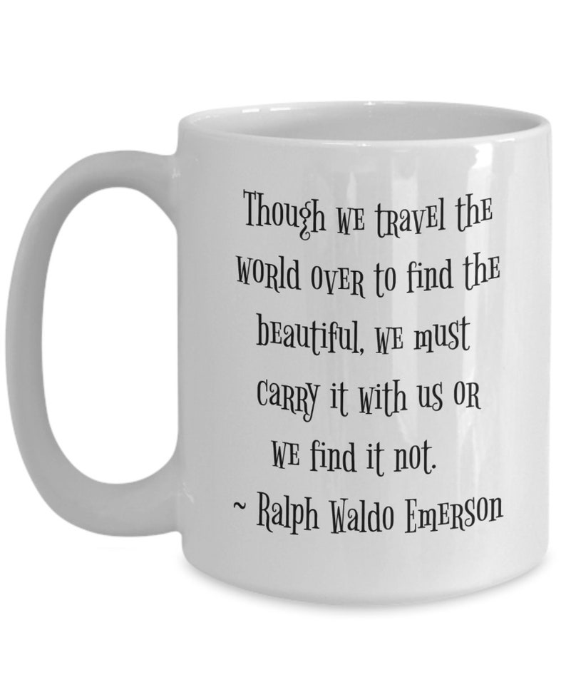 May include: White ceramic coffee mug with a black quote by Ralph Waldo Emerson: "Though we travel the world over to find the beautiful, we must carry it with us or we find it not."