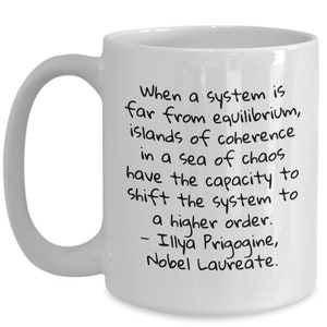 May include: White ceramic coffee mug with a black handwritten quote by Ilya Prigogine, Nobel Laureate. The quote reads: "When a system is far from equilibrium, islands of coherence in a sea of chaos have the capacity to shift the system to a higher order."