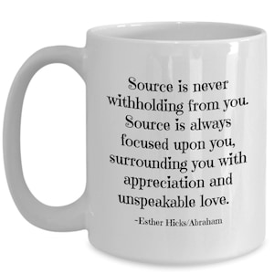 May include: White ceramic coffee mug with a black quote from Esther Hicks/Abraham that reads: "Source is never withholding from you. Source is always focused upon you, surrounding you with appreciation and unspeakable love."