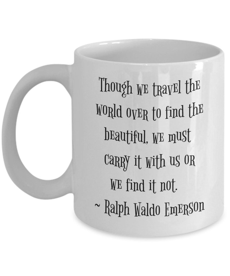 May include: White ceramic coffee mug with a black quote by Ralph Waldo Emerson: "Though we travel the world over to find the beautiful, we must carry it with us or we find it not."