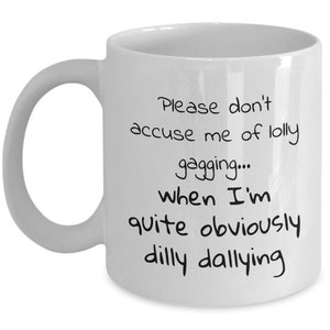 May include: White ceramic coffee mug with black text that reads "Please don't accuse me of lolly gagging... when I'm quite obviously dilly dallying."