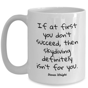May include: White ceramic mug with a curved handle. The mug features black text that reads: "If at first you don't succeed, then skydiving definitely isn't for you." The quote is attributed to Steven Wright.