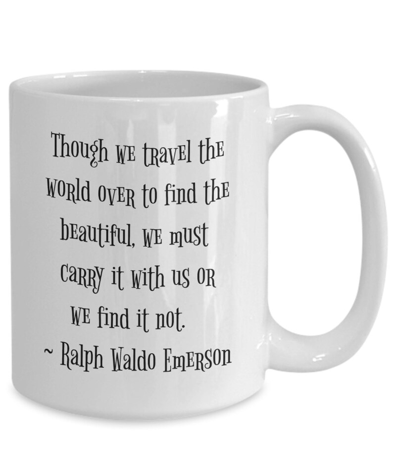 May include: White ceramic coffee mug with a black quote by Ralph Waldo Emerson: "Though we travel the world over to find the beautiful, we must carry it with us or we find it not."