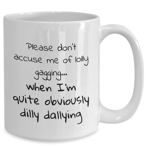 May include: White ceramic coffee mug with black text that reads: "Please don't accuse me of lolly gagging... when I'm quite obviously dilly dallying"