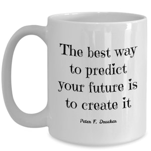 May include: White ceramic coffee mug with a black quote that reads "The best way to predict your future is to create it" and the author "Peter F. Drucker" at the bottom.