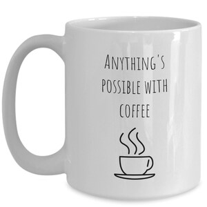 May include: White ceramic coffee mug with black text that reads "Anything's possible with coffee" and a simple black line drawing of a steaming cup of coffee.
