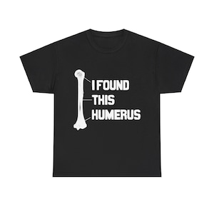 May include: Black t-shirt with a white graphic of a humerus bone and the text "I found this humerus".