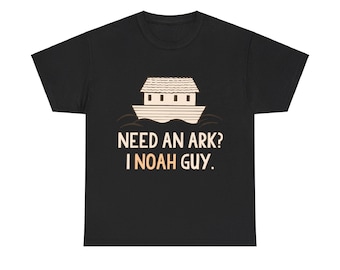 May include: Black t-shirt with a graphic of Noah's Ark and the text "NEED AN ARK? I NOAH GUY." The design features a beige ark on water with a beige roof and windows. The text is in a beige colour.