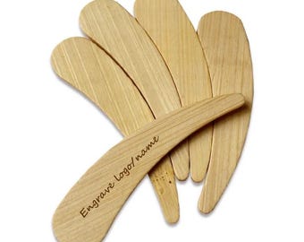 May include: Set of five wooden butter knives with a curved handle. The knives are made of natural wood and have a smooth finish. The top knife has the text "Engrave logo/name" engraved on the handle.