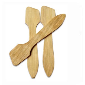May include: Four small, light brown bamboo spatulas with a flat, angled head and a long, narrow handle. The spatulas are arranged on a white background, with one overlapping the others. The bamboo has a visible wood grain.