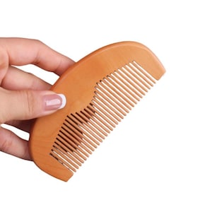 Peine de dientes finos de madera de melocotón con logo de león para el cuidado del cabello y la barba de hombre. Ideal como regalo.