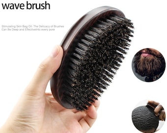 Pode incluir: Uma escova de ondas castanha escura com cerdas pretas. A escova tem um cabo de madeira curvo e foi projetada para pentear o cabelo. O texto "wave brush" é visível na imagem.
