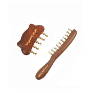 May include: Two wooden massage tools with gold-colored tips. One is a comb-like tool, and the other is a curved shape. The text "Engrave logo" is printed on both tools. These tools are designed for massage and relaxation.