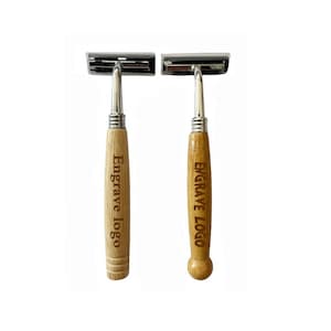 May include: Two safety razors with wooden handles and silver-colored heads. The handles are engraved with the text "Engrave logo". The razors are displayed against a white background.