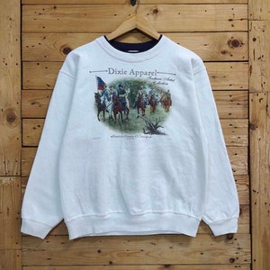 May include: White sweatshirt with a graphic print of a group of men on horseback. The print includes the text "Dixie Apparel Southern Artist Collection Forrest's Pursuit Of Straight."