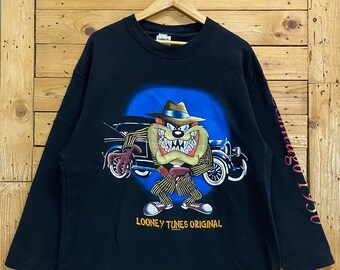 May include: Black long-sleeve shirt with a cartoon image of Taz from Looney Tunes wearing a fedora and pinstripe suit. The shirt has the text "LOONEY TUNES ORIGINAL" printed on the bottom.