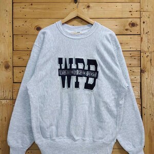 May include: A grey sweatshirt with a black embroidered patch that says "WPD WYOMING POLICE DEPT."