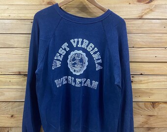 May include: A navy blue sweatshirt with the words "WEST VIRGINIA WESLEYAN" in white lettering. The sweatshirt has a crew neck and long sleeves. The design includes a circular emblem with a crest.