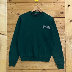 May include: A dark green crew neck sweatshirt with the text "MC DONNELL DOUGLAS" embroidered on the front in white.