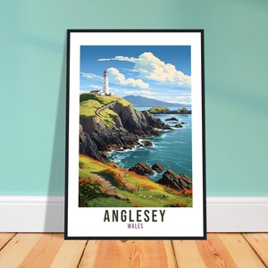 Puede incluir: Una impresión enmarcada de un faro en un acantilado rocoso con vistas al océano. El cielo es azul con nubes blancas. El texto "Anglesey, Gales" está en la parte inferior de la impresión.